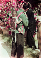 A lady carrying a baby in a traditional carrier [孭帶]