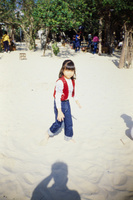 Young girl walking on a sandy beach at Shek O